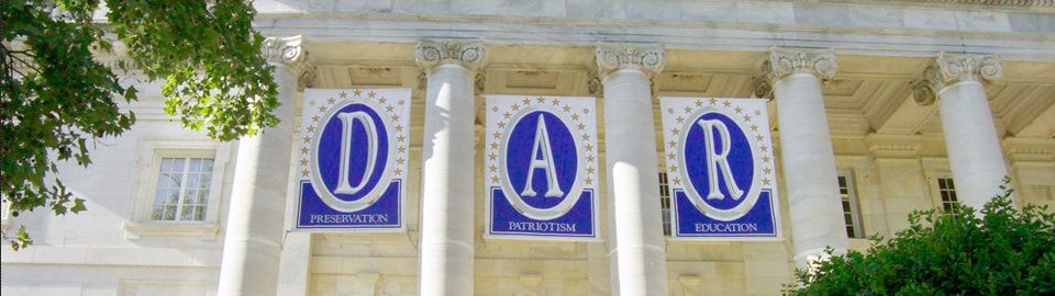 A view of the national headquarters of the Daughters of the American Revolution; a portion of five columns, part of a portico is visible; Banners spell D, A, and R, with the words Preservation, Patriotism, and Education; Used with permission from Flickr